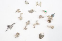 Fifteen vintage white metal charms. Including heart, boot and bell, etc.