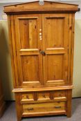 A contemporary stained pine wardrobe. With two panel doors and drawers beneath.