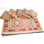 A contemporary kilim style rug and five similar tapestry cushions.
