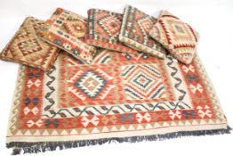 A contemporary kilim style rug and five similar tapestry cushions.