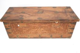A carved hardwood blanket box trunk. With metalwork decoration and swing handles.