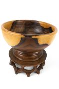 A late 20th century Chinese turned rosewood fruit bowl on carved and fretted circular stand. H23.