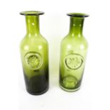 A pair of vintage Dartington green glass bottles.