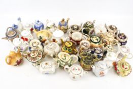 A collection of Griffin and other ceramic miniature teapots