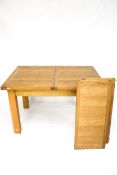 A contemporary oak extending dining table. On square supports.
