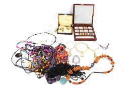 An assortment of collectables. Including strings of beads, cufflinks, a keyring, etc.
