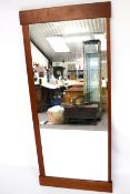 A large contemporary wooden framed wall mirror.