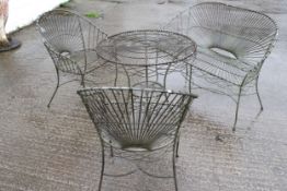 A four piece set of wirework garden furniture. Including a round table, two chairs and a bench.