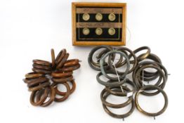 A vintage butler's room indicator and two sets of curtain rings.