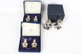 A pair of silver short round candlesticks and two pairs of silver cruets.