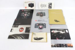 An assortment of Leica manuals and paperwork.