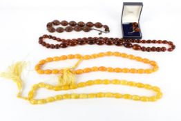 A pair of Baltic amber drop-shaped pendant earrings and four imitation-amber bead necklaces.