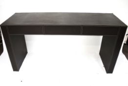 A contemporary brown leatherette covered console table. With three drawers.