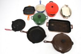 A group of assorted cast iron cookware pans. Including Le Creuset, various colours.