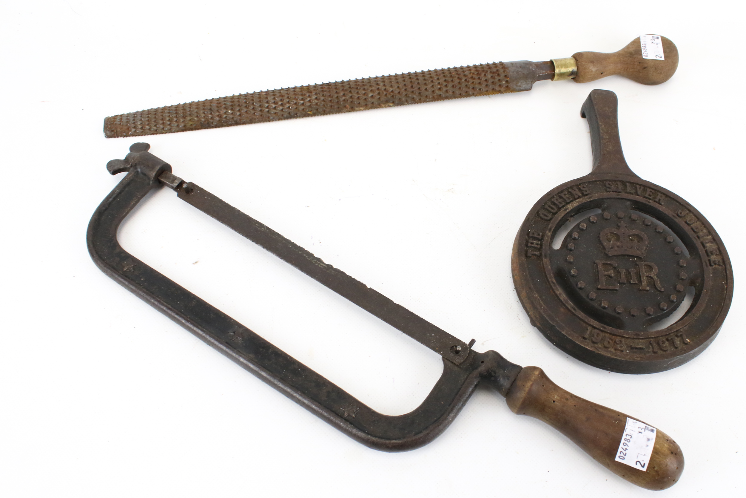 A cast iron hacksaw No 8, a horse shoe rasp and a trivet.