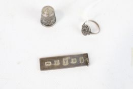 A silver ingot pendant, a marcasite ring and a thimble.