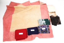 A collection of assorted fabrics, leather and a quilt.