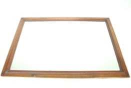 A wooden framed bevel edged wall mirror.