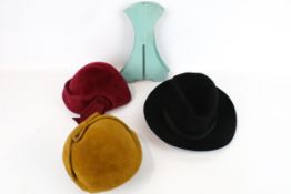 Three vintage hats plus two wooden hat stands.