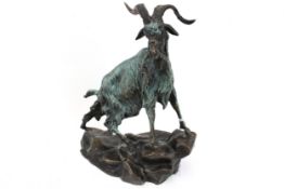 A bronze sculpture of a mountain goat, stamped 'Mene'.