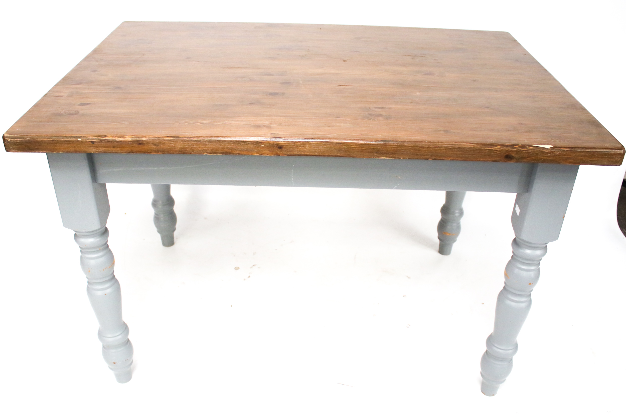 A stained rectangular dining table with grey painted turned legs.