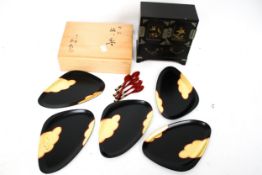 A vintage Japanese lacquer jewellery box and a set of trays and spoons.