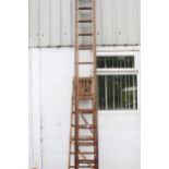 Two wooden ladders. Including an extending 14 rung ladder and a set of step ladders.