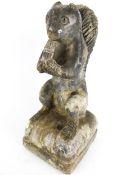 A late 18th century lead covered garden art stone sculpture of a squirrel eating an acorn.