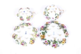 Meissen: Two late 19th century flower encrusted teacups and saucers.