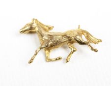 A vintage 9ct gold brooch in the form of a galloping horse. Hallmarks for London 1971, 34.