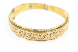 An early 20th century 9ct rose gold fancy half-hoop bangle.