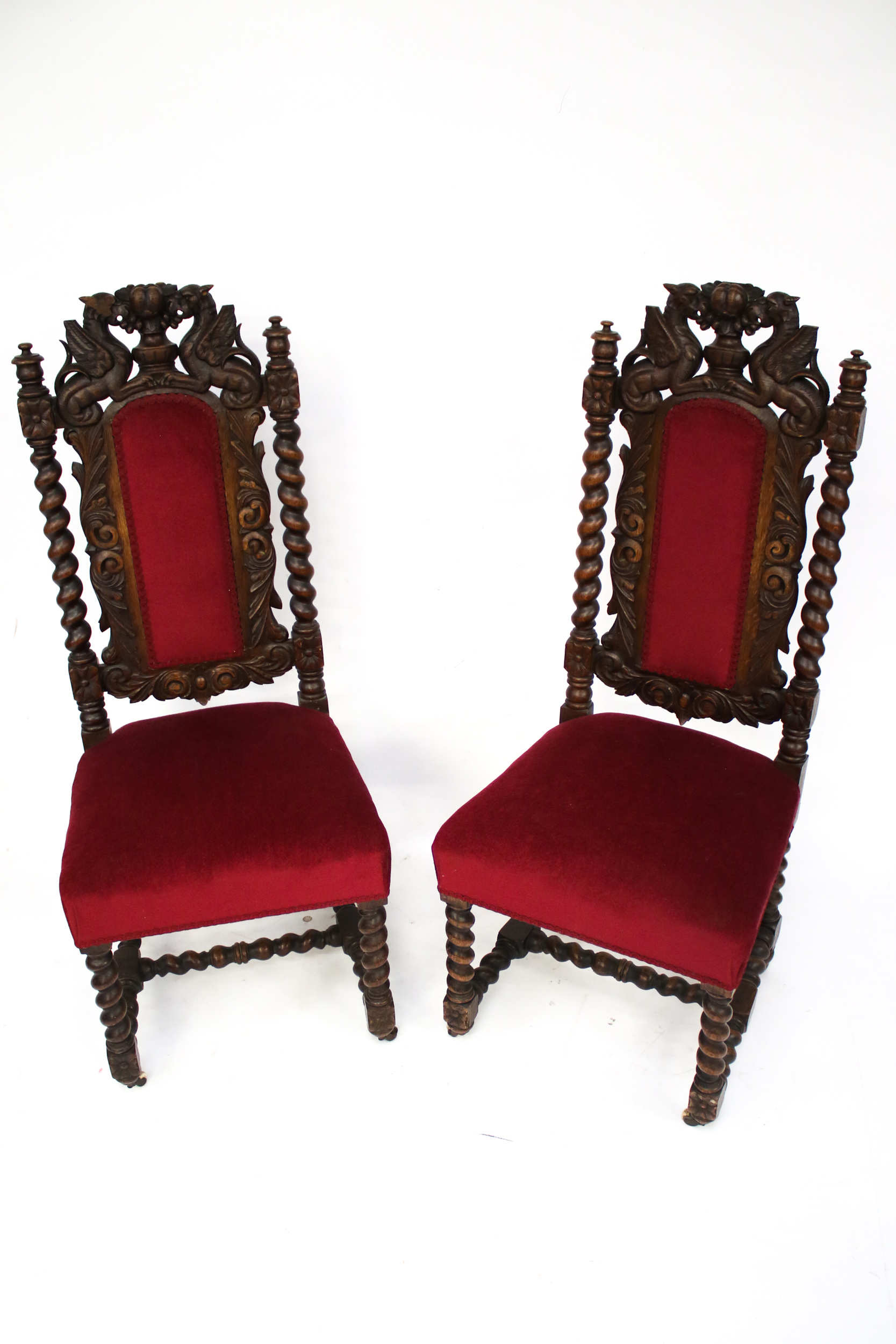 A pair of Victorian heavily carved oak chairs.