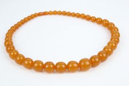 An opaque amber graduated off-round bead necklace. The 41 beads graduated approx. 20.