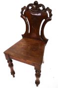 A mahogany hall chair with carved shield back.