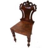 A mahogany hall chair with carved shield back.