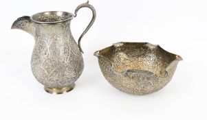 An Indian white metal baluster shaped milk jug and a shaped round sugar(?) bowl.
