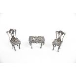 A pair of Edwardian silver miniature chairs and a dressing table.