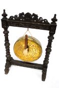 A Victorian oak and large brass riveted dinner gong on a heavily carved stand.