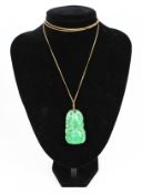 An early 20th century Chinese jadeite pendant, on a gold long curb chain.