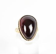A drop-shaped cabochon garnet later adapted as a ring.