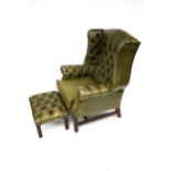 A 20th century Georgian Style green leather button back upholstered wing back armchair and