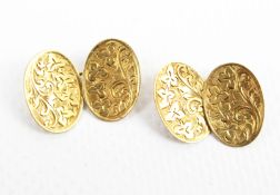A pair of early 20th century 18ct gold floral engraved concave oval twin panel cufflinks.