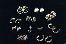 Eleven pairs of 9ct gold and yellow metal stud and hoop earrings.
