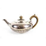 A George IV silver compressed-round and part fluted teapot.