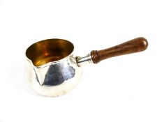 A silver brandy saucepan with a wood handle.