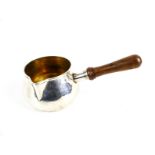 A silver brandy saucepan with a wood handle.