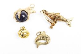 Four 9ct gold pendants or charms including an eagle's claw.