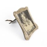 An Edwardian silver mounted shaped-rectangular easel-back photograph frame.