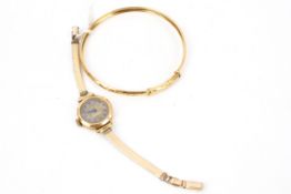 A modern 9ct gold bangle and a lady's 9ct gold cased wrist watch.