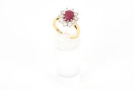 An 18ct gold, ruby and diamond oval cluster ring. Centred with an oval mixed-cut ruby approx. 1.